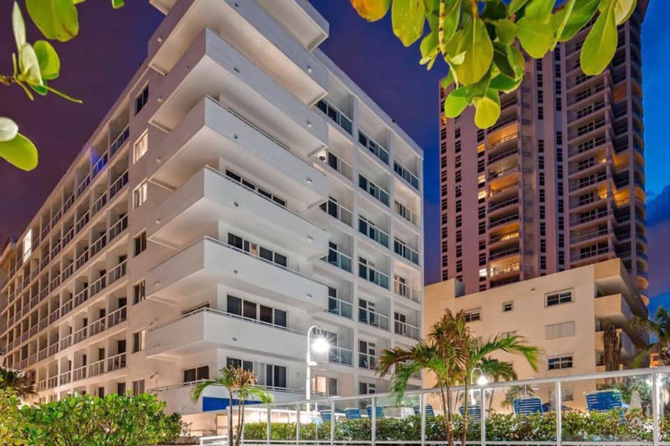 Modern beachfront resort buildings at dusk with tropical landscaping