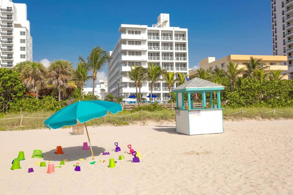 Beach area with children's sand toys, umbrella, and coastal resort buildings