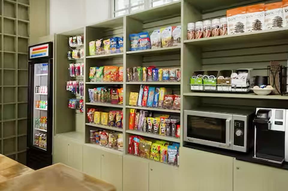 Well-stocked convenience pantry with snacks, beverages, microwave, and refrigerator
