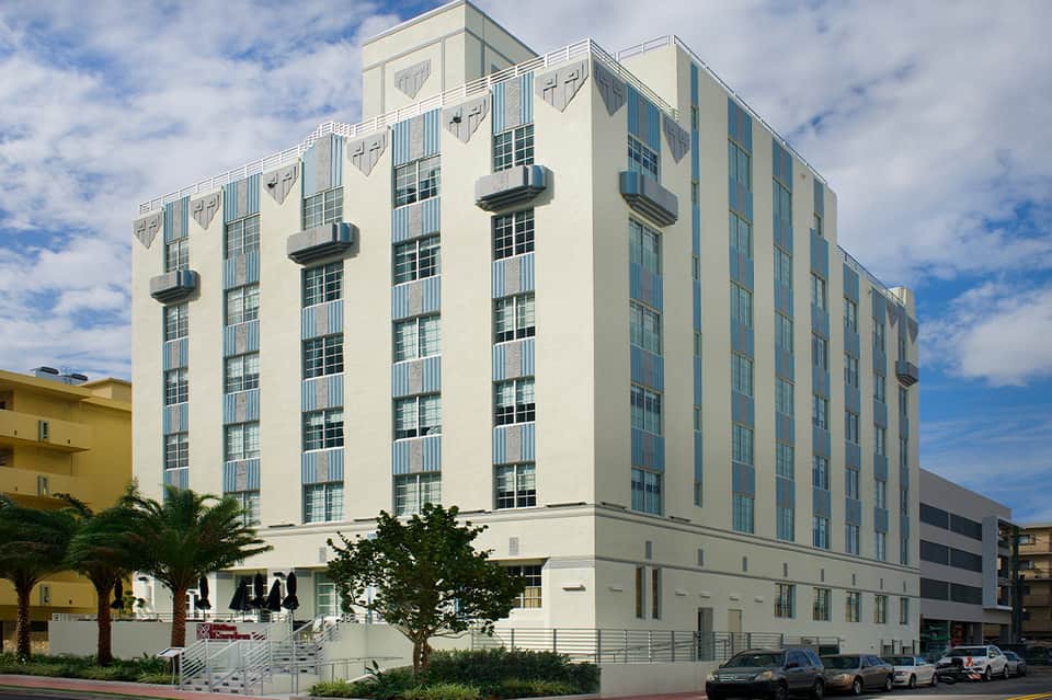 Art Deco style white hotel building with geometric window patterns and blue accents