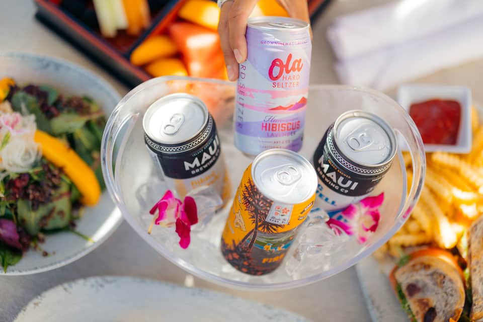 Craft beverages and local food displayed on a table with colorful drinks and appetizers