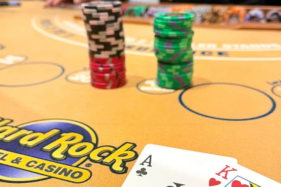 Casino gaming table with poker chips and playing cards on yellow felt surface