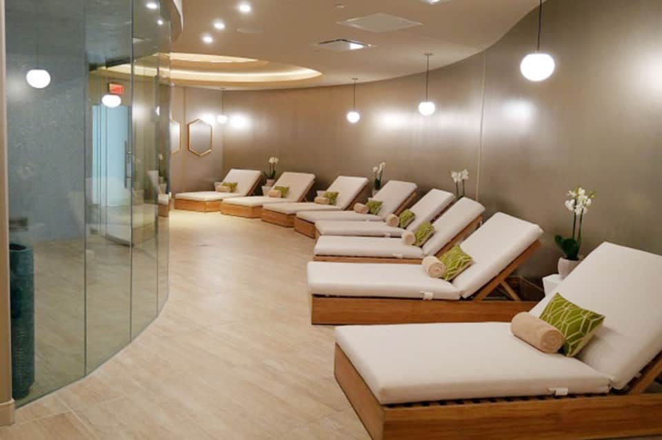 Spa relaxation room with multiple wooden loungers and soft ambient lighting