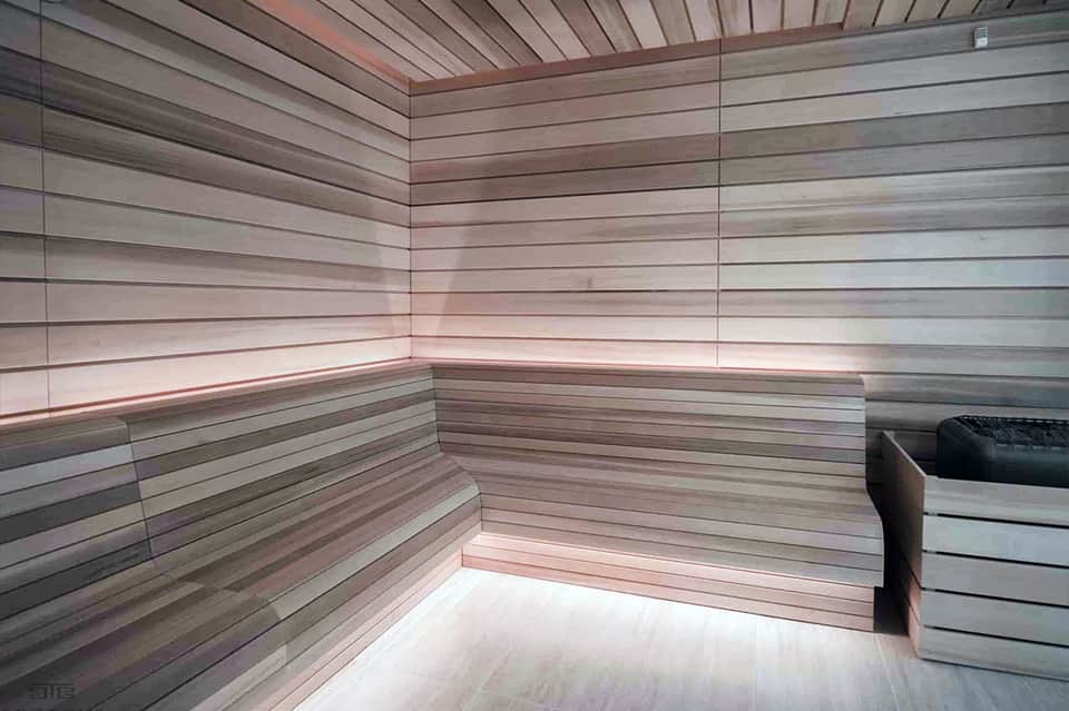Modern sauna interior with light wood paneling and built-in benches, minimalist design