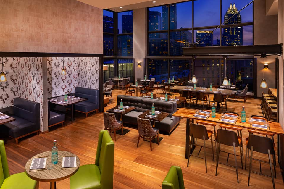 Upscale restaurant with city skyline views, modern furniture, and twilight ambiance