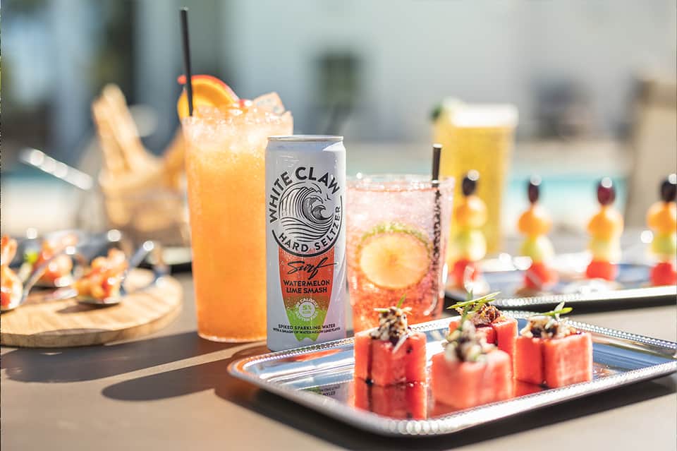 Poolside cocktails and appetizers featuring hard seltzer and colorful mocktails