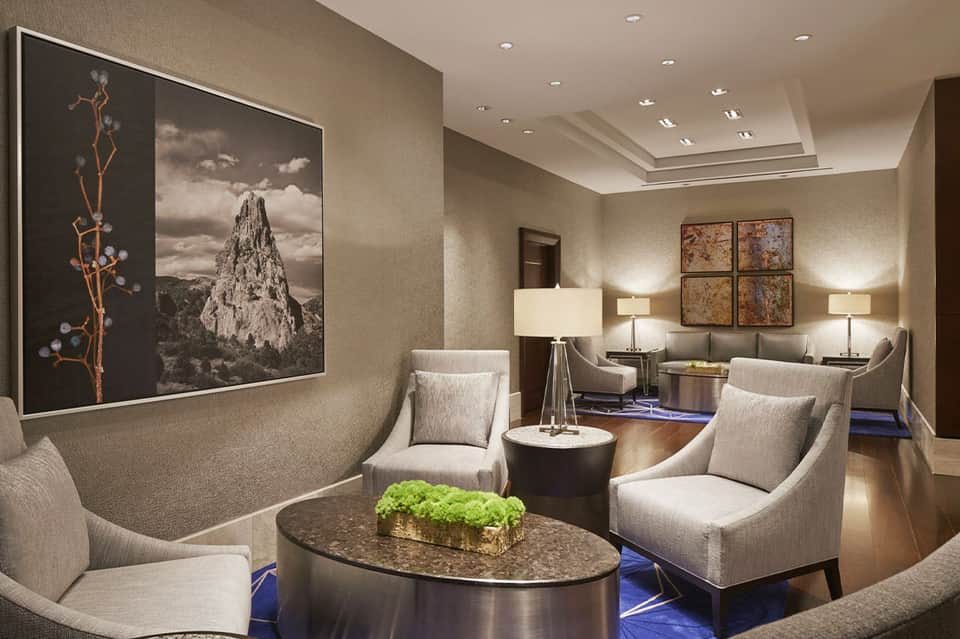 Elegant lounge seating area with neutral furnishings, framed artwork, and recessed ceiling lighting