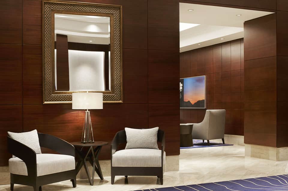 Elegant lobby lounge with dark wood walls, contemporary furniture, and framed artwork