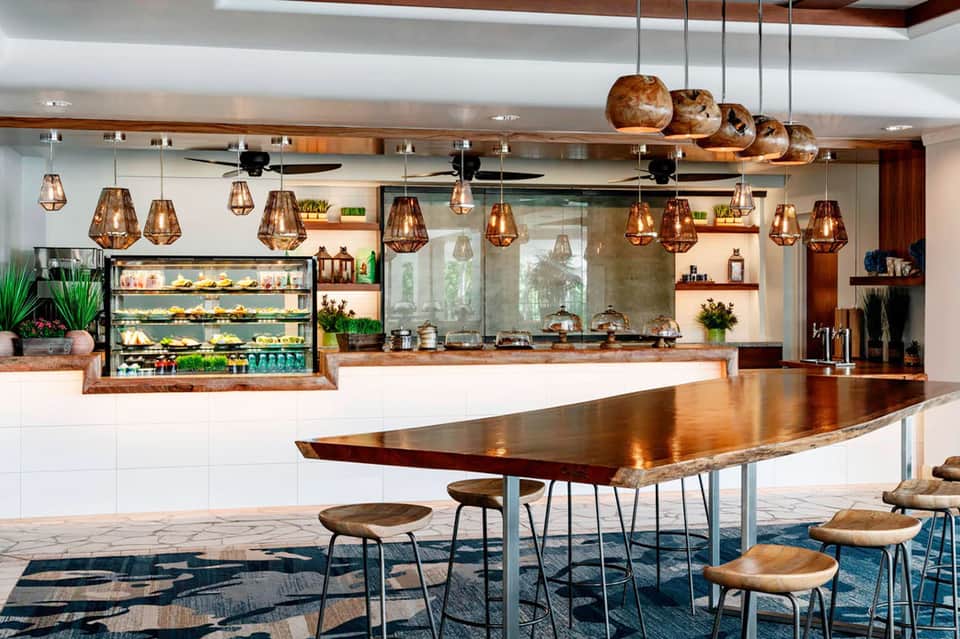 Modern resort restaurant with copper pendant lights, open kitchen, and wood accents