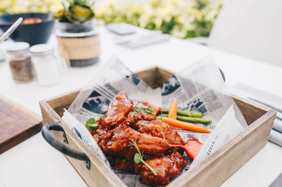 Grilled meat appetizers served in wooden tray at outdoor resort dining table