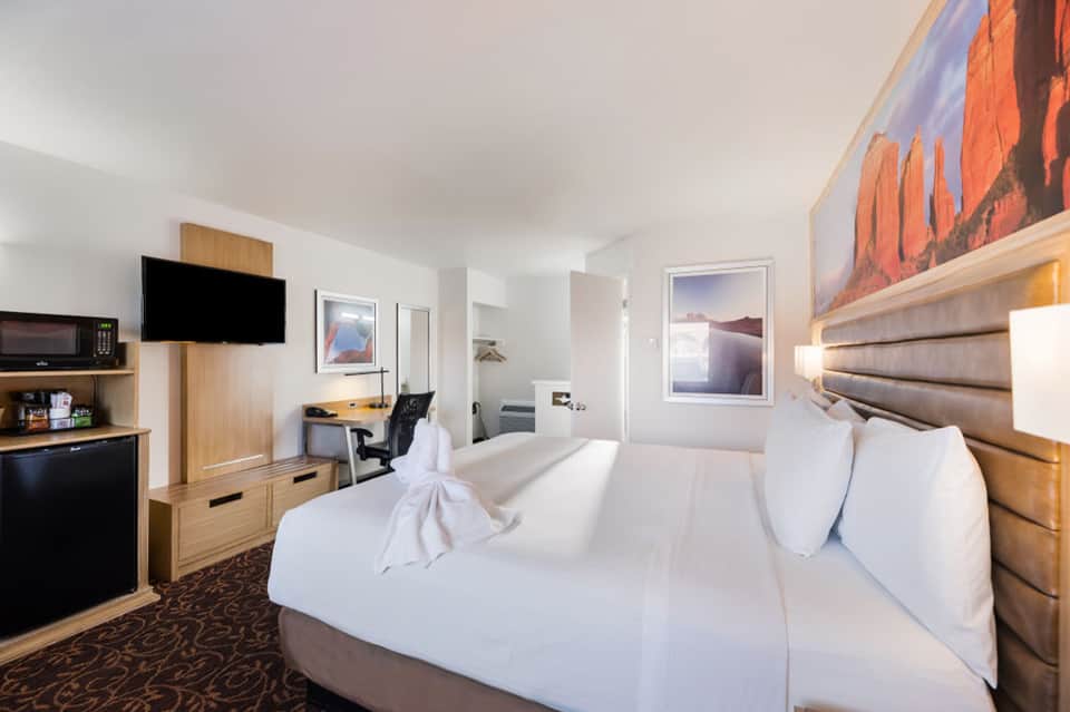 Contemporary hotel room with two queen beds, flat-screen TV, desk, and modern furnishings