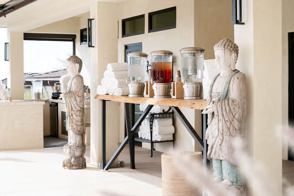 Beverage station with coffee dispensers, towels, and stone statues