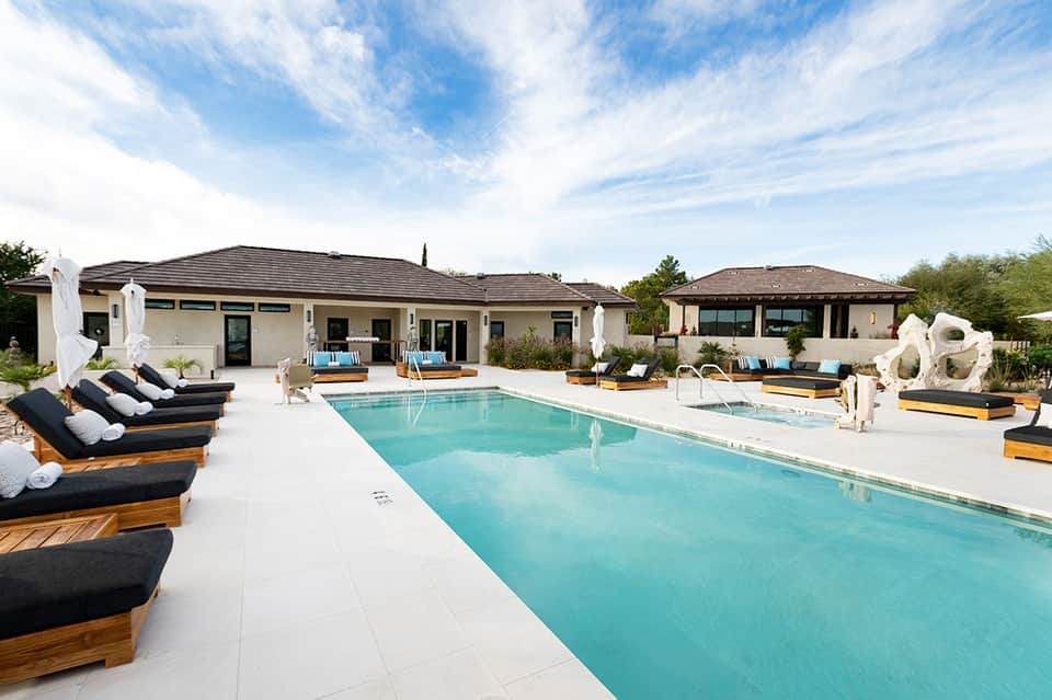 Resort pool with loungers and modern architecture set against desert landscape