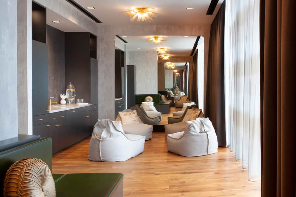 Luxury spa relaxation lounge with white bean bags, mirrored walls, and golden ceiling lights