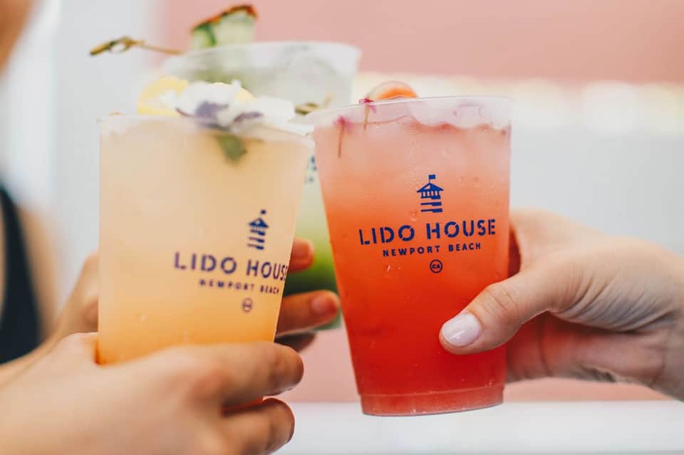 Two colorful cocktails from Lido House Newport Beach with citrus garnishes and ice
