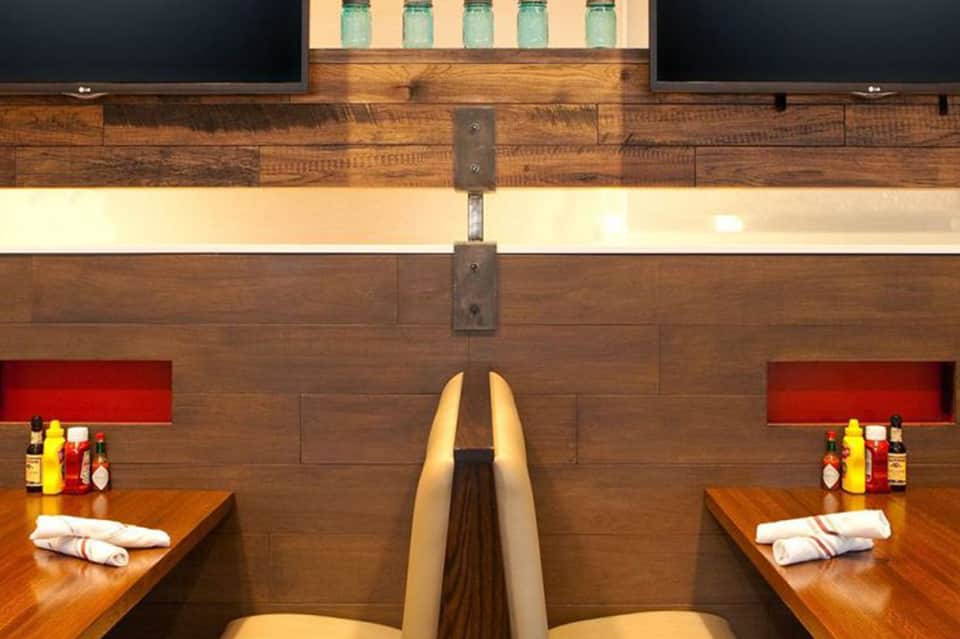 Modern dual-sink spa bathroom with wood accents and red tile wall details