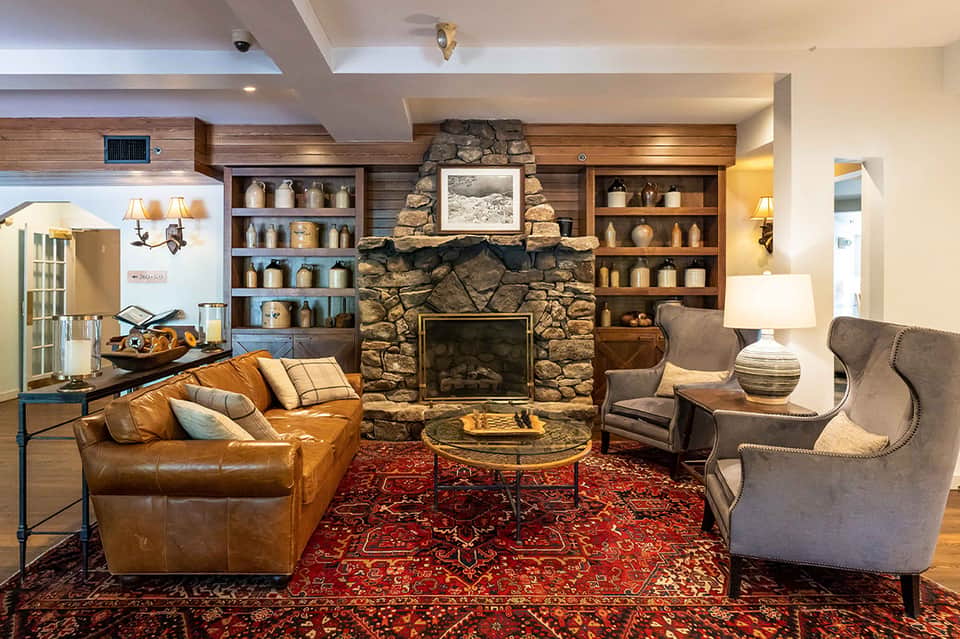 Upscale resort lounge with leather sofa, fireplace, stone accent wall, and ambient lighting