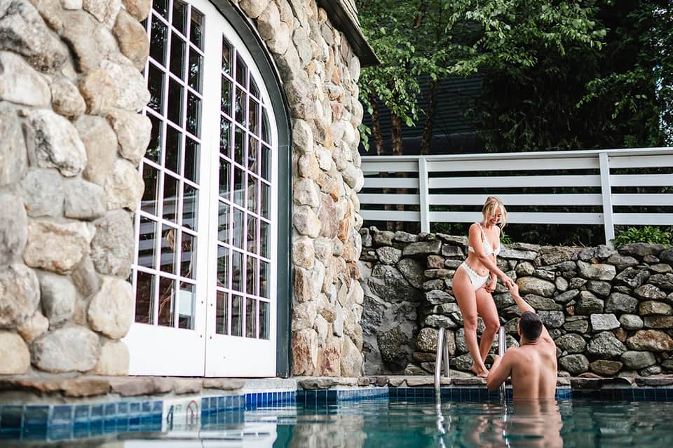 Stone cottage pool house with couple relaxing in small private swimming pool