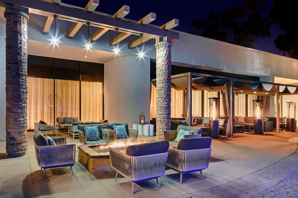 Illuminated outdoor lounge area with modern furniture and covered seating at night