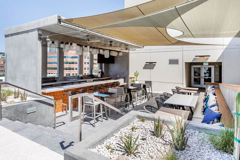 Modern outdoor bar and lounge area with retractable awning