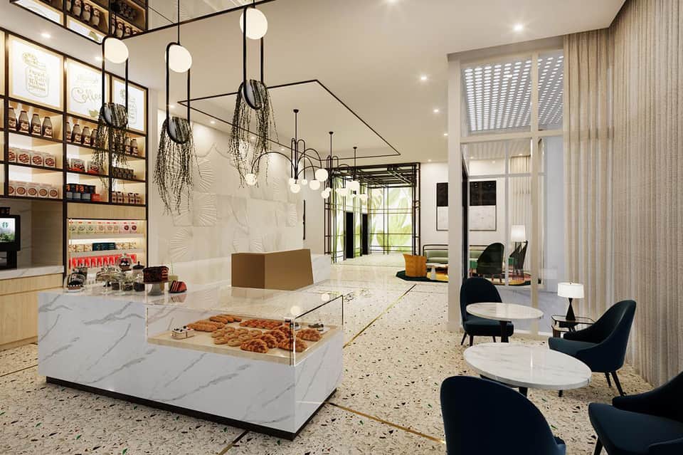 Modern hotel lobby featuring marble counters, hanging plant decor, pendant lights, retail shelves, and contemporary seating