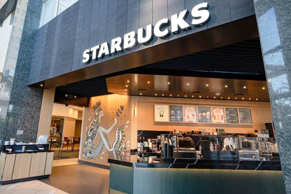 Starbucks storefront with modern dark facade and warm interior lighting in shopping center