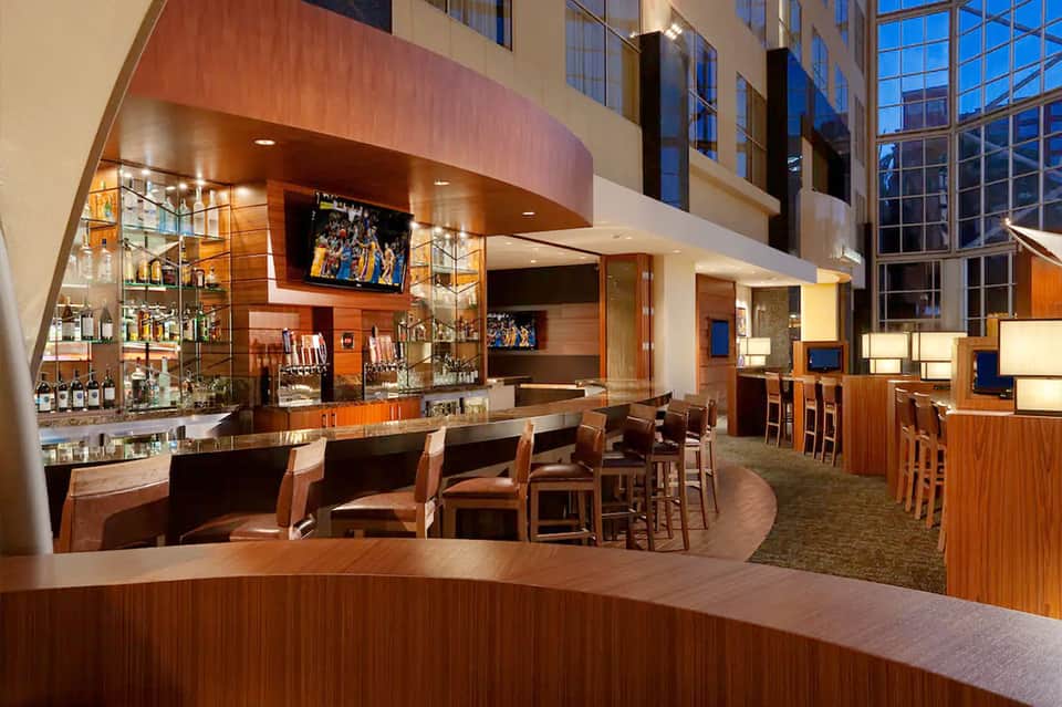 Modern hotel bar and lounge with wood finishes and curved architectural elements