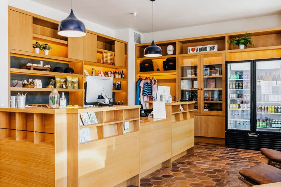 Modern hotel lobby with wooden shelving, desk, and merchandise displays