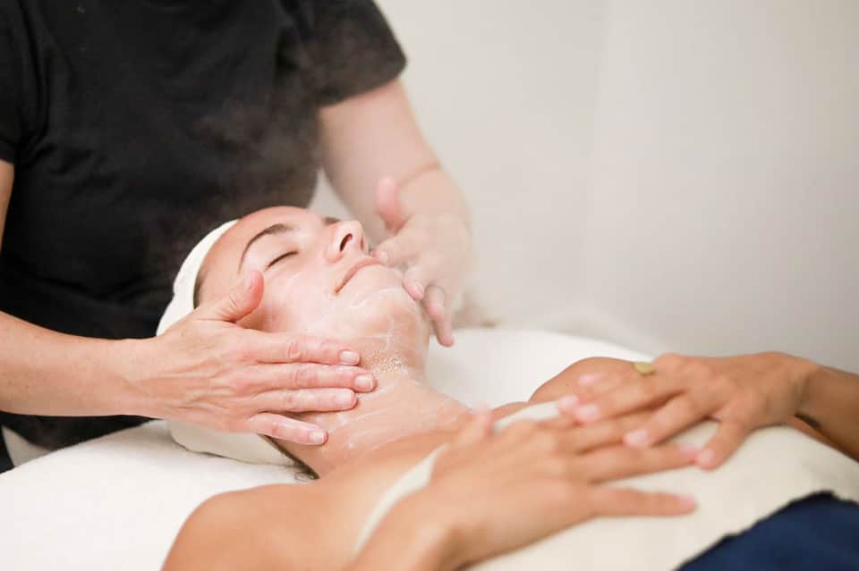 Facial massage treatment with therapist applying skincare products to client's face