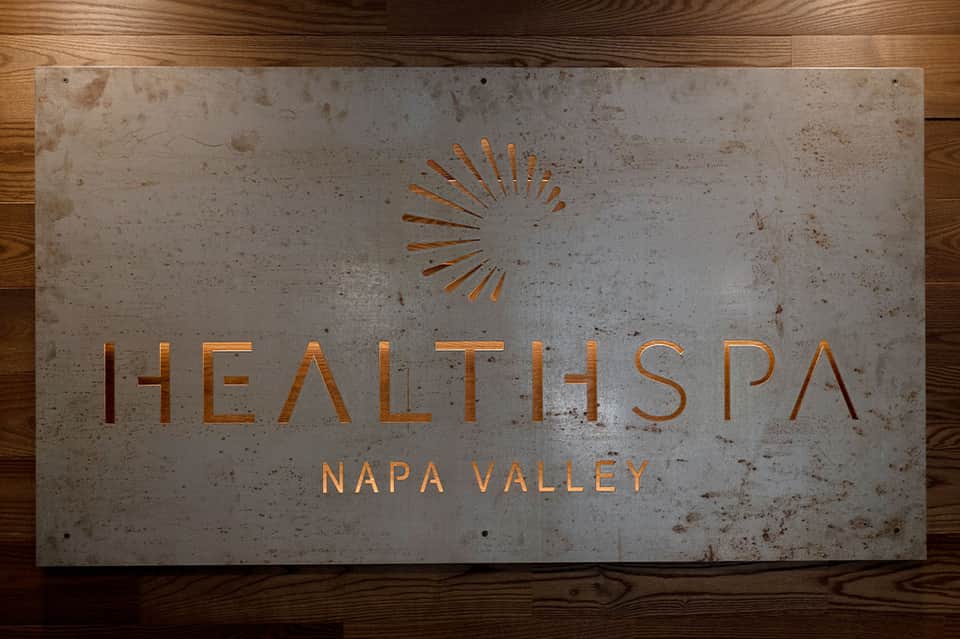 Health Spa Napa Valley sign in concrete and copper on wooden floor