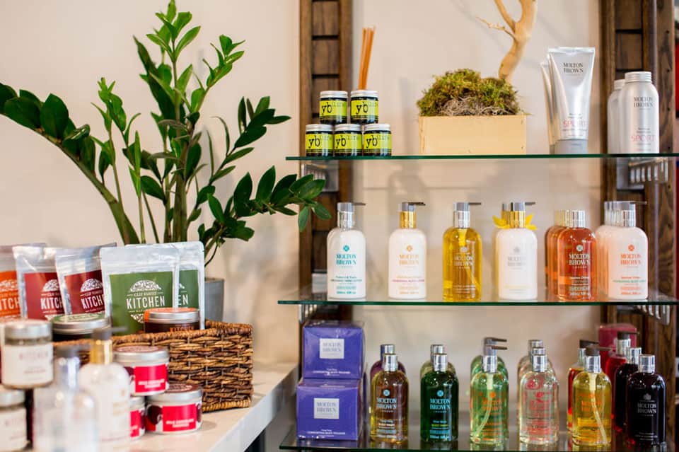 Luxury spa retail display with Molton Brown products on glass shelves and potted greenery