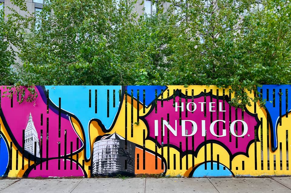 Hotel exterior with vibrant pink, blue, and yellow graphic mural design on wall