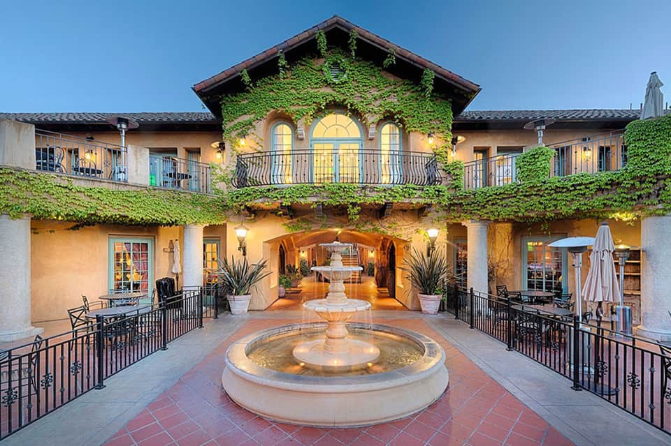 Spanish colonial courtyard with ivy-covered walls, central fountain, and arched passageways