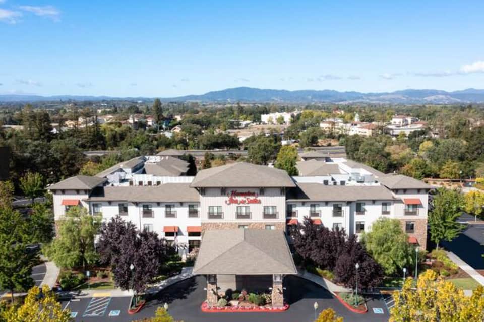 Aerial view of Hampton Inn hotel with mountainous landscape backdrop