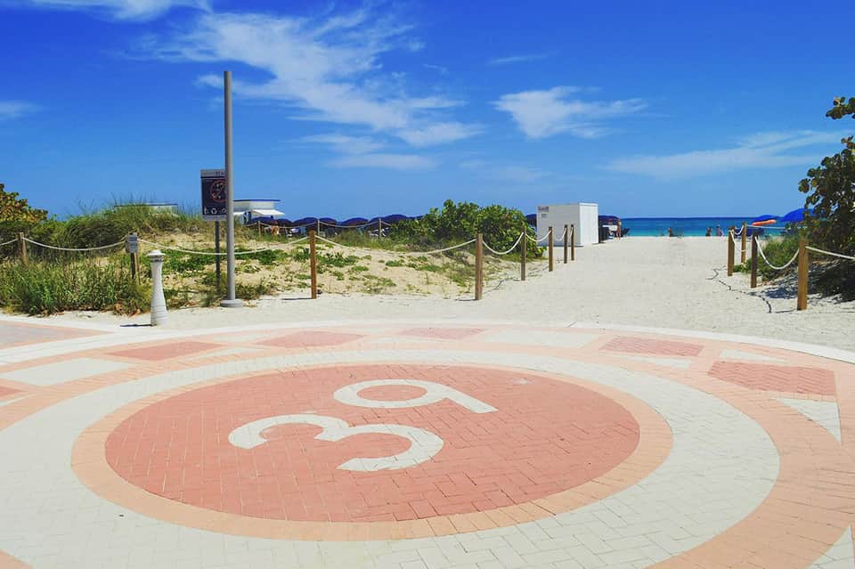 Beachfront promenade with Beeman Hotel logo leading to sandy beach