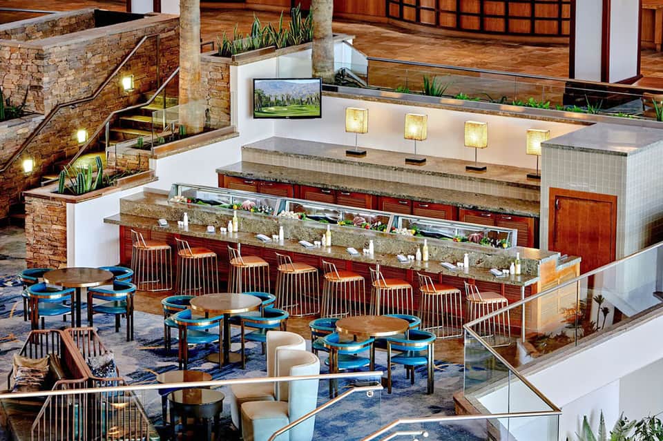 Hotel lobby bar and lounge with stone stairs, wood beams, and modern furnishings