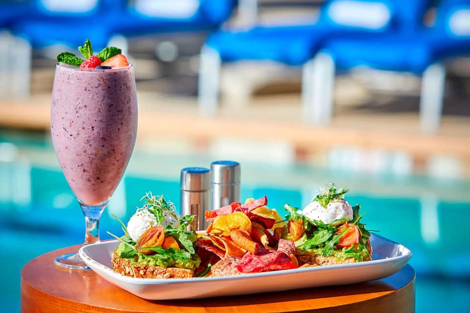 Gourmet salad and berry smoothie served poolside at resort restaurant