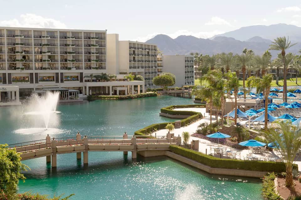 Resort buildings with fountain and lagoon surrounded by mountains