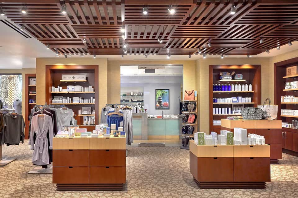 Upscale spa retail shop with wooden shelving, products, clothing, and checkout counter