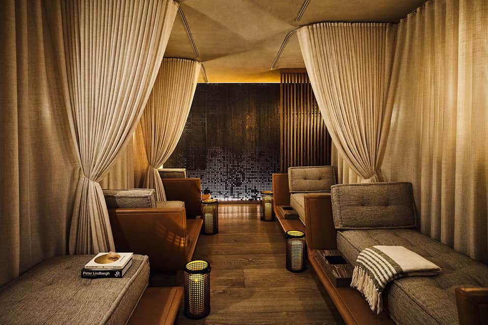Luxurious spa lounge with cream drapes, comfortable seating, and ambient lighting