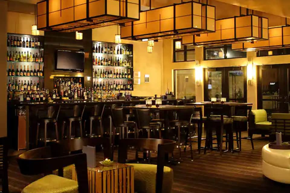 Upscale bar lounge with extensive liquor selection, dark wood furnishings, and ambient lighting