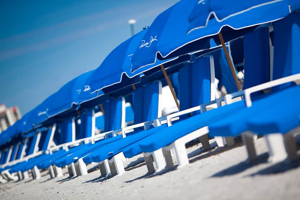 Close-up of bright blue beach cabanas with white trim and wooden details