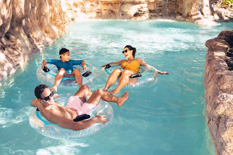 Group of people floating in clear turquoise lagoon surrounded by rocky limestone cliffs