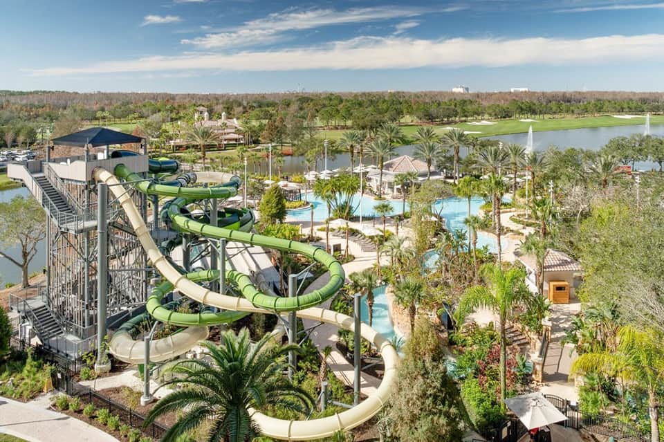Aerial view of massive resort water park with water slides, pools, and lush landscape