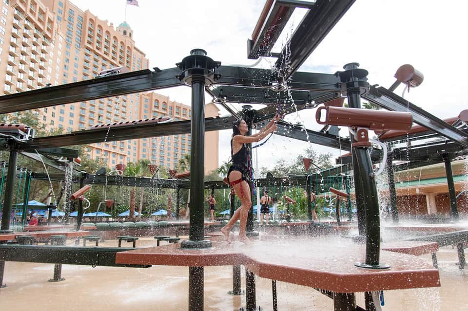 Interactive water play area with overhead spray structures in urban setting