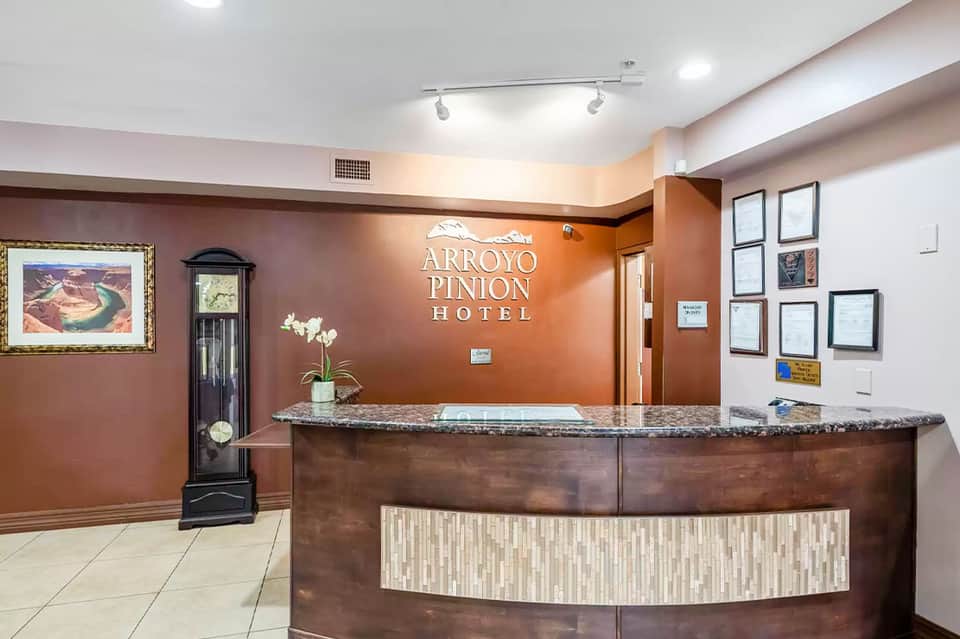 Arroyo Pinion Hotel front desk reception area with warm orange walls and professional counter