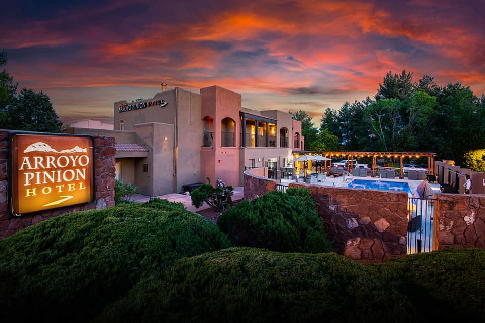 Arroyo Pinion Hotel exterior at sunset with pink adobe-style building and pool area