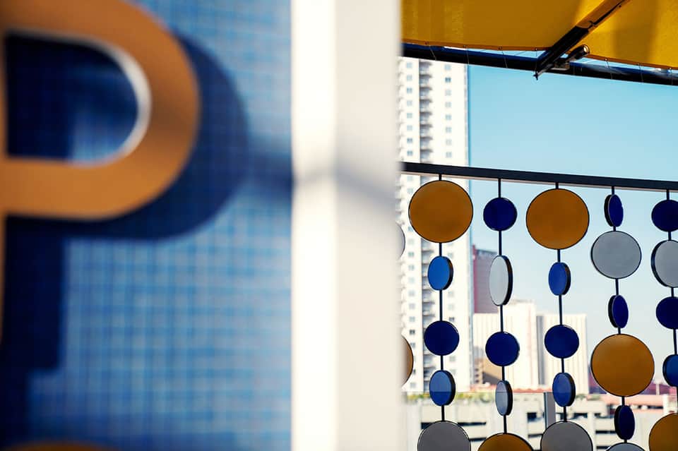 Geometric wind chime decoration hanging on balcony overlooking high-rise buildings and city skyline
