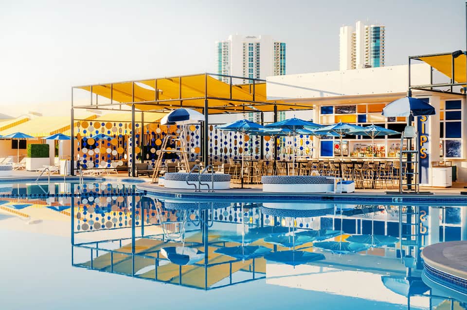 Modern rooftop pool bar with yellow umbrellas and colorful contemporary design