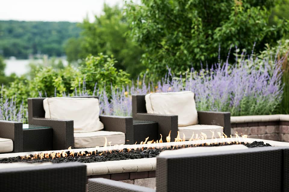 Fire pit with lounge chairs in garden setting with lavender plants